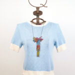 Maglia celeste polvere in cotone a maniche corte con collana