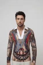 Uomo che indossa una camicia a maniche lunghe con un design artistico e dettagli colorati, in un contesto neutro.
