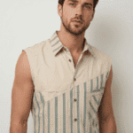 Modello maschile che indossa una camicia senza maniche beige con righe blu, in stile casual e moderno. Ideale per outfit estivi e informal.