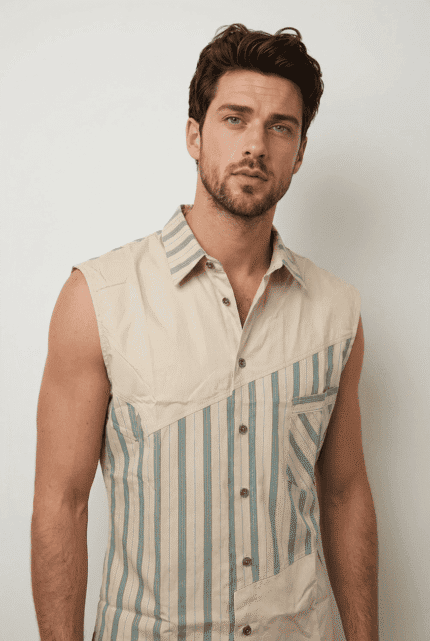 Modello maschile che indossa una camicia senza maniche beige con righe blu, in stile casual e moderno. Ideale per outfit estivi e informal.