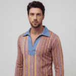 Uomo in camicia a righe colorate con colletto blu, in posa su sfondo neutro. Stile moderno e alla moda.
