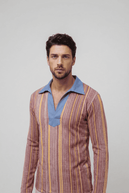 Uomo in camicia a righe colorate con colletto blu, in posa su sfondo neutro. Stile moderno e alla moda.