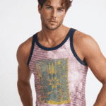 Uomo giovane in canotta colorata con design grafico, sfondo neutro, stile casual e moderno.