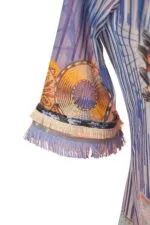 Manica di un abito estivo con dettagli colorati, frange decorative e motivi geometrici, ideale per look casual e freschi.