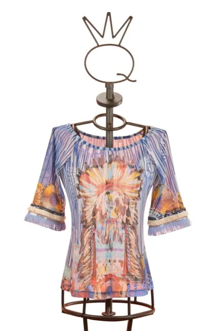 Maglietta colorata con maniche a tre quarti e motivo grafico ispirato alla cultura nativa americana, esposta su un manichino di design. Ideale per un look estivo e informale.