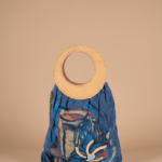 Borsa alla moda con manico circolare in pelle, realizzata in tessuto blu con disegni astratti colorati, ideale per look casual ed eleganti.