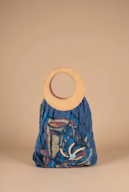 Borsa alla moda con manico circolare in pelle, realizzata in tessuto blu con disegni astratti colorati, ideale per look casual ed eleganti.