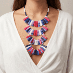 Collana moderna e colorata indossata da una donna, composta da pezzi in blu, rosa e rosso, su sfondo neutro. Perfetta per aggiungere un tocco di stile a qualsiasi outfit.