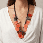 Collana colorata con dettagli floreali e geometrici, indossata da una donna con abbigliamento bianco, perfetta per aggiungere un tocco di stile a qualsiasi outfit.