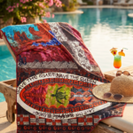 Asciugamano colorato con motivi artistici disteso su un lettino accanto a una piscina, con occhiali da sole e un cappello di paglia, in un ambiente tropicale.