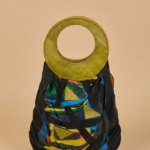 Borsa di design unico con manico circolare in pelle verde e motivo astratto multicolore su sfondo nero, ideale per un look contemporaneo e alla moda.