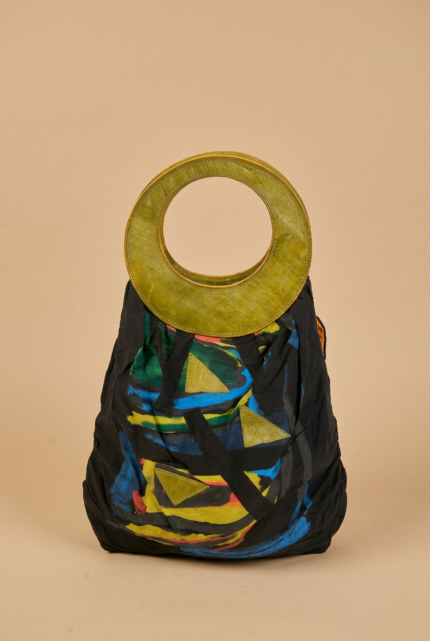 Borsa di design unico con manico circolare in pelle verde e motivo astratto multicolore su sfondo nero, ideale per un look contemporaneo e alla moda.