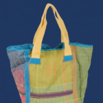 Borsa a spalla colorata con manici gialli, realizzata in tessuto misto con motivi geometrici e ricami, ideale per l'uso quotidiano e le attività all'aperto.
