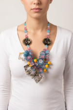 Collana in PVC ispirata a Positano, caratterizzata da fiori colorati, elementi in plastica e dettagli vivaci, indossata da una donna in maglietta bianca.