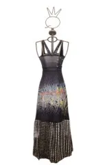 Abito lungo da donna con stampa grafica, caratterizzato da una scollatura profonda e dettagli a strati, esposto su un manichino stilizzato. Ideale per occasioni estive e serate eleganti.