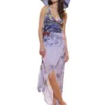 Modella che indossa un abito estivo lungo con motivi floreali e un cappello di paglia, posando su una superficie chiara. L'outfit è elegante e adatto per occasioni estive.