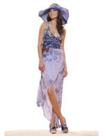 Modella che indossa un abito estivo lungo con motivi floreali e un cappello di paglia, posando su una superficie chiara. L'outfit è elegante e adatto per occasioni estive.