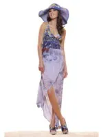Model wearing a long summer dress with floral pattern and a straw hat, posing on a clear surface. The outfit is elegant and suitable for summer occasions.