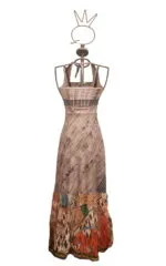 Abito lungo da donna con stampa artistica, caratterizzato da una parte superiore in tonalità neutre e una gonna decorata con motivi colorati e geometrici. Esposizione su manichino stilizzato. Ideale per occasioni estive e casual.