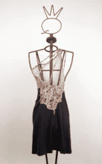 Robe d'été à bretelles croisées, avec un motif géométrique et une jupe noire, présentée sur un mannequin en métal.