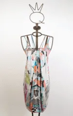 Abito estivo multicolore con spalline, esposto su un manichino. Il design presenta una combinazione di motivi geometrici e floreali, perfetto per occasioni informali e calde giornate estive.