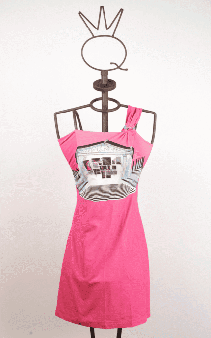 Abito rosa con spallina unica e stampa grafica, esposto su un manichino con supporto a forma di corona. Perfetto per look estivi e casual.