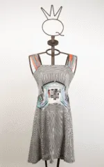 Abito estivo a righe bianche e nere con dettagli colorati, esposto su una gruccia artistica a forma di corona, ideale per look casual e alla moda.