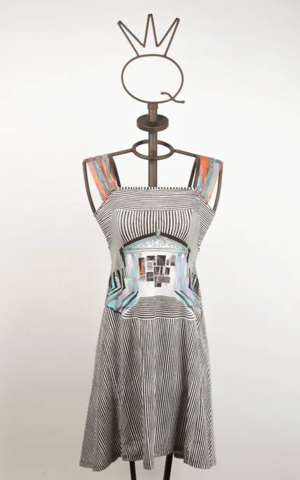 Abito estivo a righe bianche e nere con dettagli colorati, esposto su una gruccia artistica a forma di corona, ideale per look casual e alla moda.