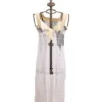 Robe longue sur mannequin, en tissu léger et transparent, avec des détails de couleurs claires et des décorations artistiques. Parfaite pour les occasions estivales et les looks décontractés. 