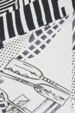 Dettaglio di un tessuto con un motivo grafico in bianco e nero, caratterizzato da linee, forme geometriche e illustrazioni stilizzate di oggetti. Ideale per abbigliamento moderno e alla moda.