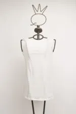 Manichino con maglietta bianca senza maniche, posizionato su uno sfondo neutro, ideale per presentazioni di moda o abbigliamento femminile.