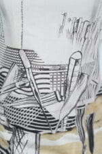 Dettaglio di una maglietta con un design artistico che presenta linee nere su sfondo chiaro, raffigurante strumenti da disegno e trame geometriche.