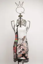 Abito estivo a maniche corte con un design astratto multicolore, esposto su un manichino. Il vestito presenta motivi geometrici e floreali, ideale per occasioni casual e di moda.