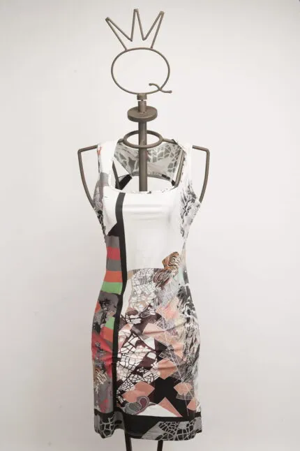 Abito estivo a maniche corte con un design astratto multicolore, esposto su un manichino. Il vestito presenta motivi geometrici e floreali, ideale per occasioni casual e di moda.