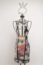 Abito femminile con stampe colorate su manichino, caratterizzato da un design moderno e artistico, con dettagli in bianco e nero e colori vivaci. Ideale per occasioni casual o eventi estivi.