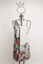 Abito senza maniche con design astratto e colori vivaci, esposto su un manichino in metallo con una corona decorativa. Ideale per occasioni estive e look informali.