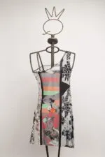 Abito estivo multicolore con design grafico esposto su un manichino con testa a forma di corona, ideale per occasioni casual e moda contemporanea.