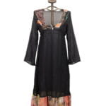 Black long dress with floral details, long sleeves and V-neckline, presented on a decorative mannequin. Ideal for summer occasions and informal events. 