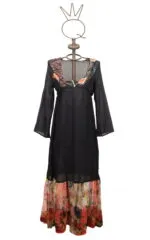 Abito lungo nero con dettagli floreali, maniche lunghe e scollatura a V, presentato su un manichino decorativo. Ideale per occasioni estive e eventi informali.