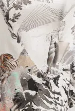 Dettaglio di una maglietta con una stampa artistica che combina elementi grafici e paesaggi astratti, caratterizzata da tonalità neutre e forme geometriche.