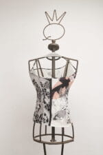 Top in tessuto con design geometrico, esposto su un manichino di metallo. Ideale per outfit estivi e casual.