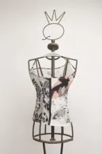 Top in tessuto con design geometrico, esposto su un manichino di metallo. Ideale per outfit estivi e casual.