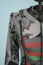 Giacca con cappuccio dallo stile moderno, caratterizzata da un design astratto con colori vivaci e motivi grafici, esposta su un manichino.