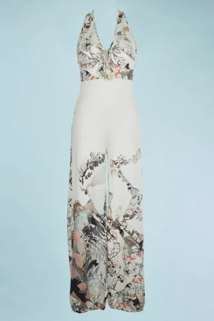 Tuta estiva elegante con scollo a V, caratterizzata da un motivo floreale e geometrico in tonalità neutre e pastello, ideale per occasioni casual e eventi estivi.