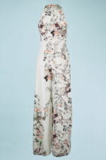 Elegant long-sleeved jumpsuit with abstract print in neutral tones and colorful details, on a light blue background. Perfect for formal events and special occasions.