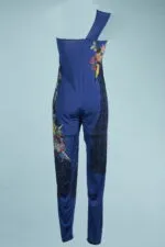 Elegant blue jumpsuit with single shoulder pad and floral details, ideal for special occasions or summer events. Modern and eye-catching design, perfect for a fashionable look.