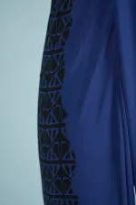 Blue dress with black details and geometric pattern, foregrounded on a light blue background. Perfect for casual occasions and summer fashion.