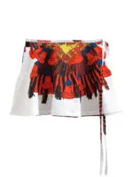 Gonna corta bianca con stampa colorata di un motivo tribale in rosso, blu e giallo, perfetta per un look estivo audace e alla moda.