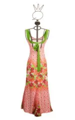 Longue robe d'été aux imprimés floraux dans les tons rouge et vert, présentée sur un élégant mannequin au design unique. Parfaite pour les occasions estivales et les événements décontractés.