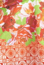 Tissu floral avec des roses rouges et des fleurs blanches sur un fond clair, décoré d'un motif géométrique orange. Idéal pour les vêtements d'été et les accessoires de mode.